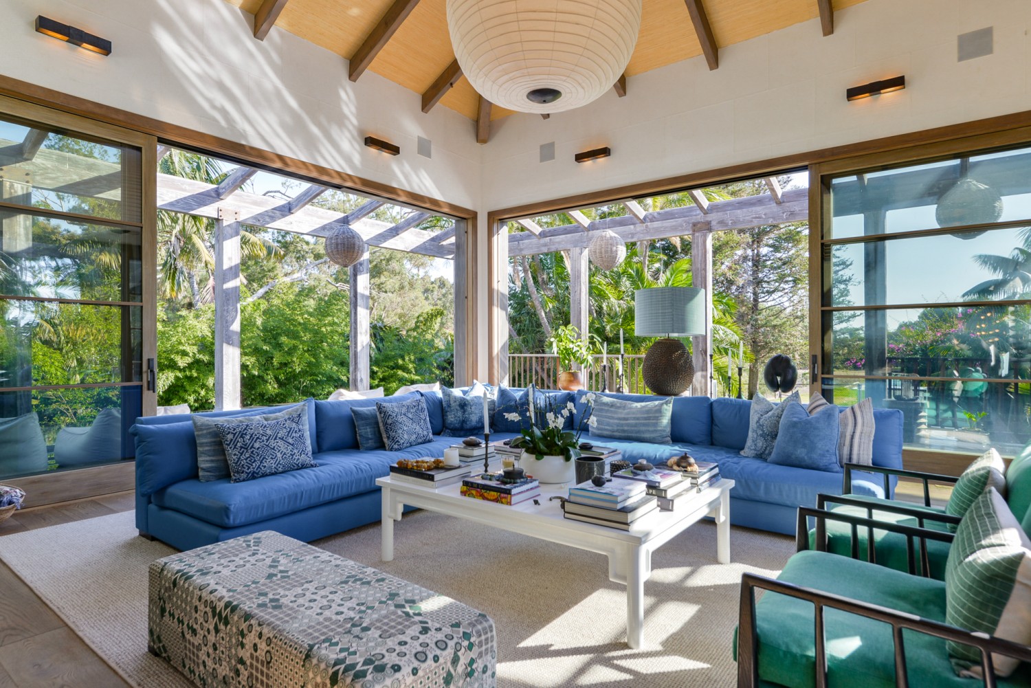 Bright great room with soaring ceilings, oversized windows, and tropical garden views at a private Malibu estate.