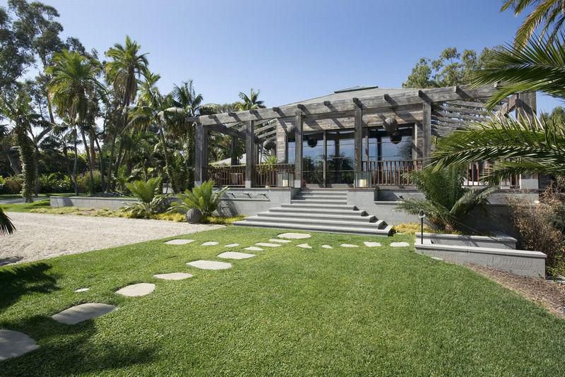 Gardens Front lawn surrounded by mature palms and tropical landscaping at a private Malibu estate in Malibu.
