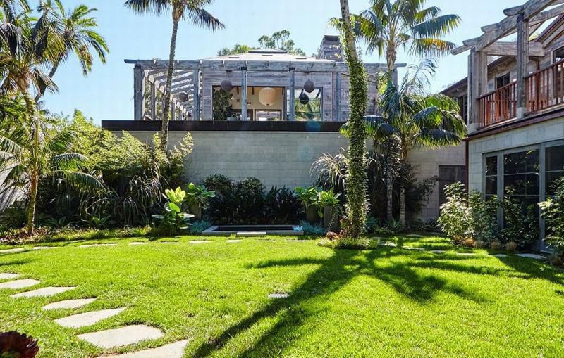 Hidden tropical courtyard surrounded by mature palm trees and lush landscaping at a Balinese-inspired private Malibu estate.