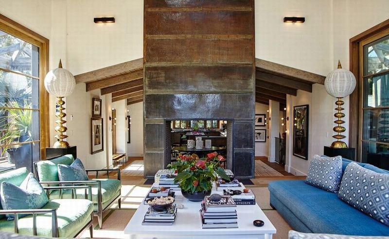 Spacious great room featuring vaulted ceilings, a dramatic fireplace, and comfortable seating overlooking lush gardens.