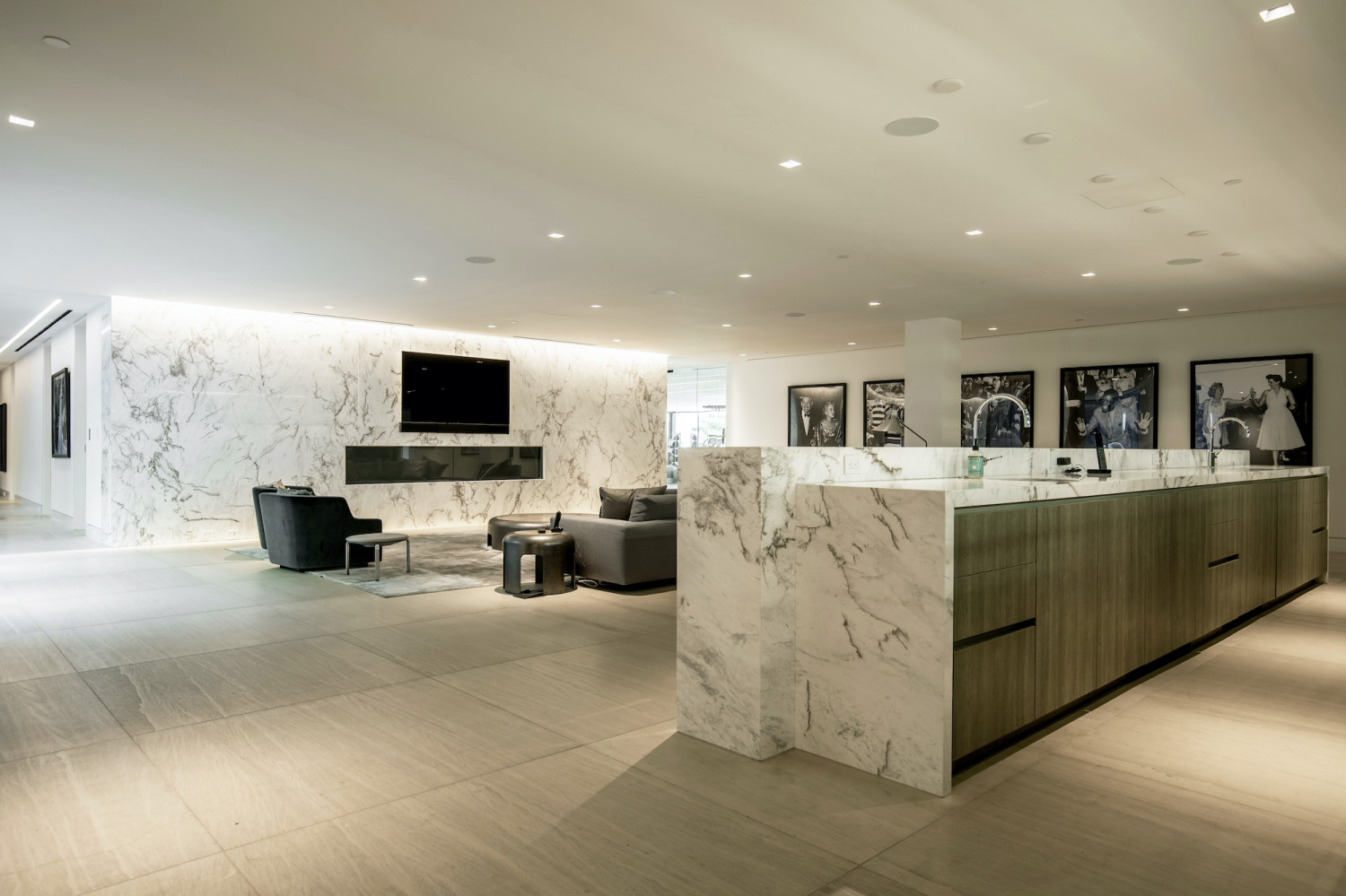 Contemporary lounge featuring a dramatic marble fireplace and open entertaining space inside a luxury estate.
