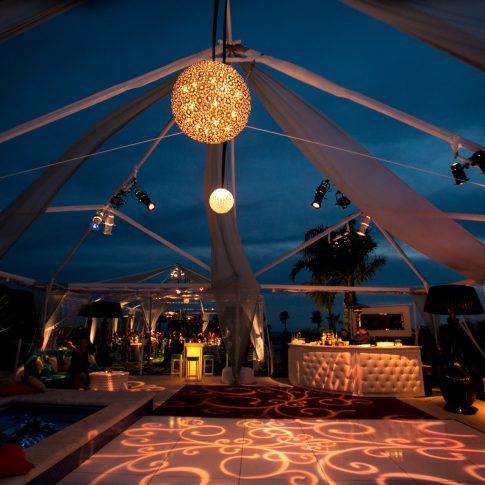 Elegant tented reception at a private estate featuring custom lighting, lounge seating, a modern bar, and luxury event design for an evening celebration.