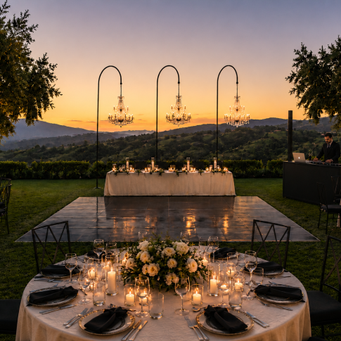 Luxury corporate event venue in Los Angeles featuring a private estate reception with a DJ, elegant dance floor, candlelit dining tables, crystal chandeliers, and panoramic sunset views.