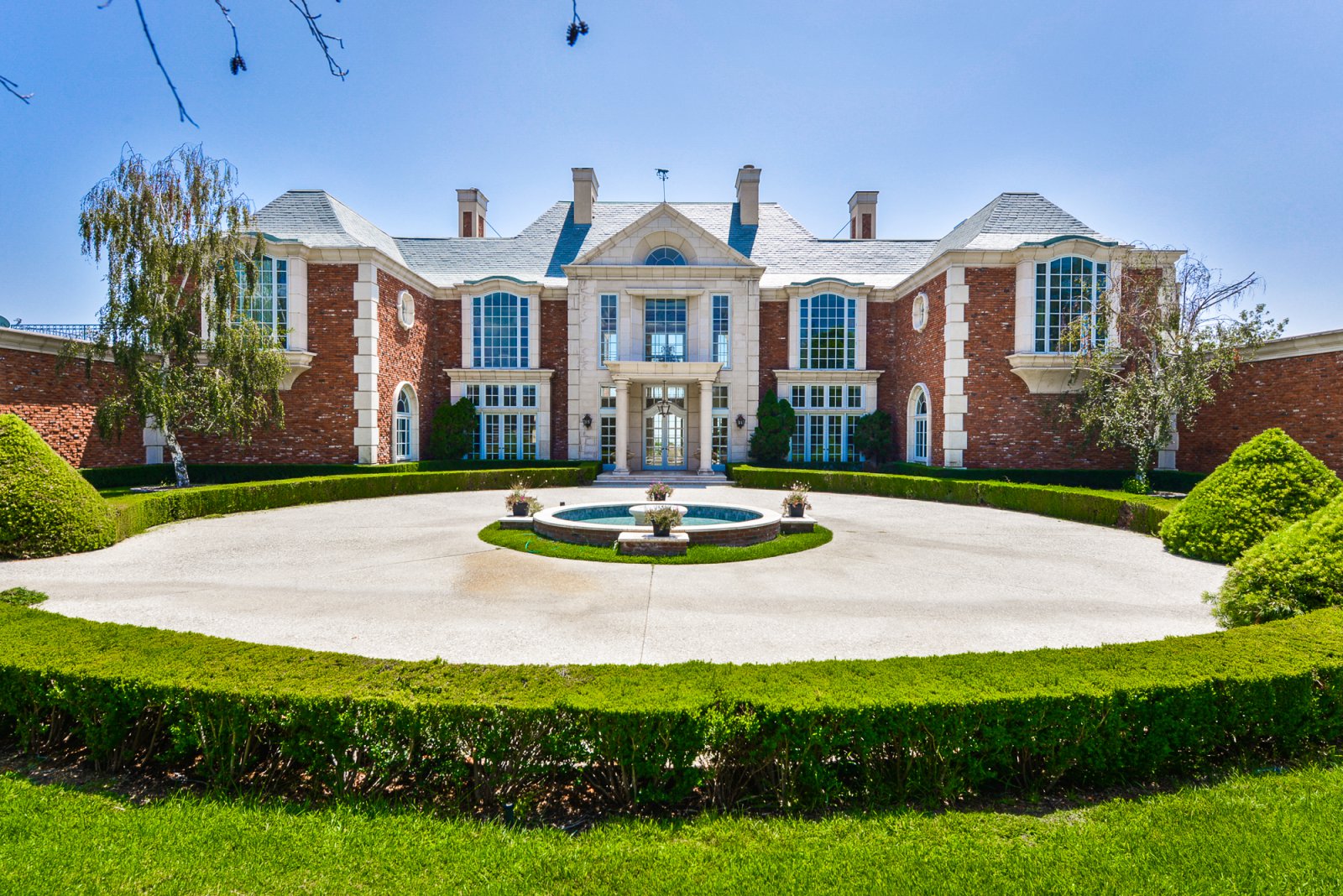 Elegant front courtyard with circular fountain and manicured landscaping at a classic Pasadena private estate.