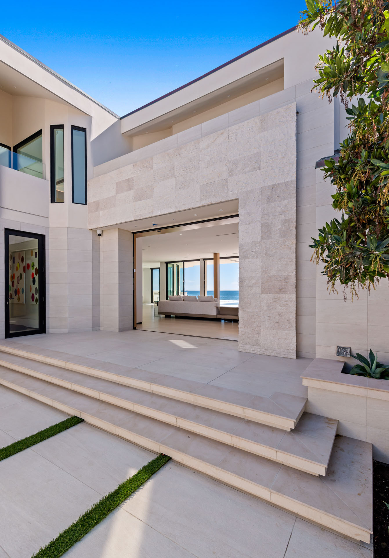 Front exterior of a modern Malibu beachfront estate with contemporary architecture and clean architectural lines.