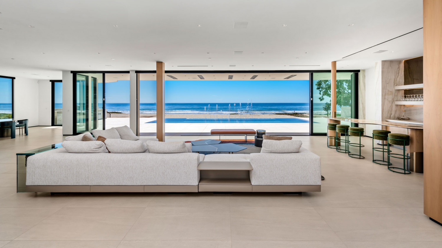 Contemporary living room with floor-to-ceiling glass and panoramic Pacific Ocean views.