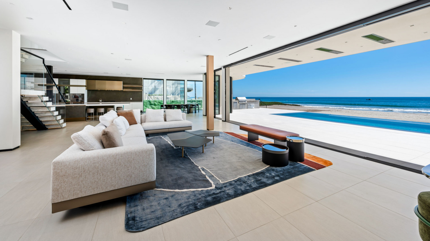 Contemporary living room with floor-to-ceiling glass and panoramic Pacific Ocean views.
