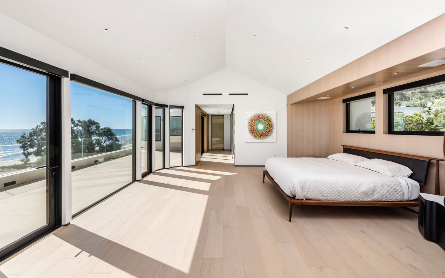 Ocean view primary suite with floor-to-ceiling windows in a modern Malibu beachfront estate.