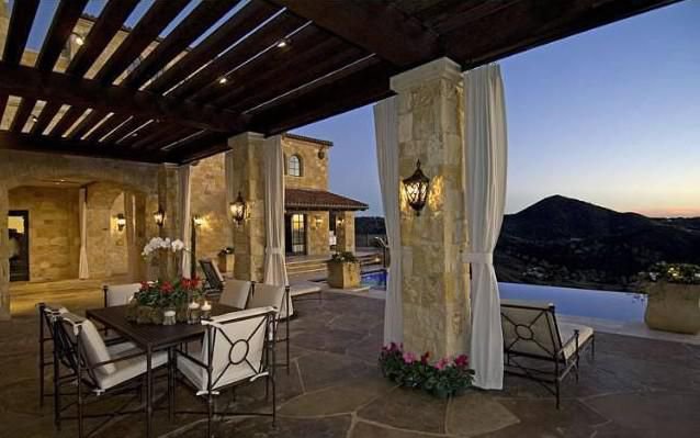 Elegant outdoor terrace overlooking vineyards and mountain views at sunset.
