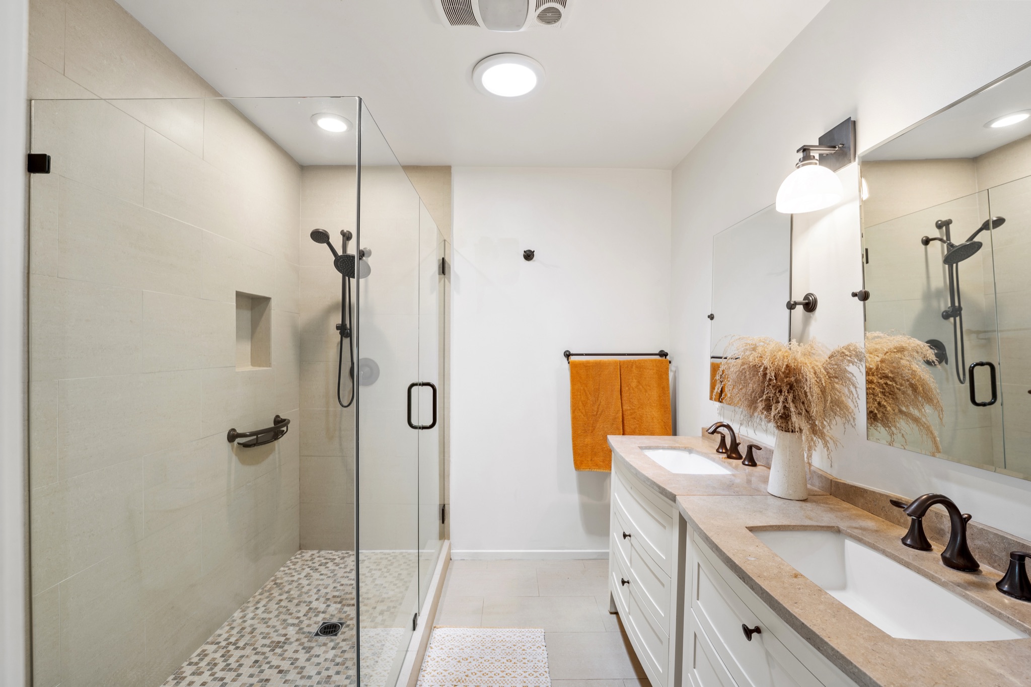 Bright contemporary primary bathroom with a double vanity, walk-in glass shower, and modern finishes at a private Calabasas retreat.