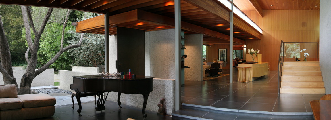 Architectural interior by John Lautner with grand piano, open staircase, and indoor-outdoor living