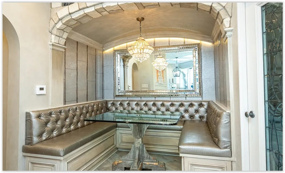 Elegant built-in breakfast nook with crystal chandeliers and custom upholstered seating.