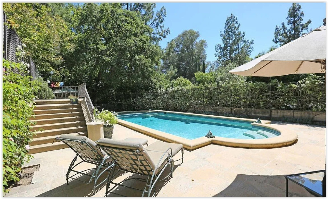 Private swimming pool surrounded by mature landscaping at a luxury Pasadena estate.
