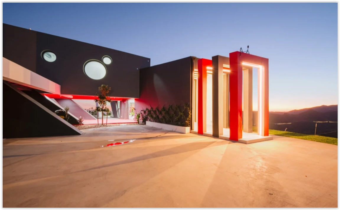 Bold architectural entrance with illuminated design elements and sweeping mountain views at a modern Malibu retreat.