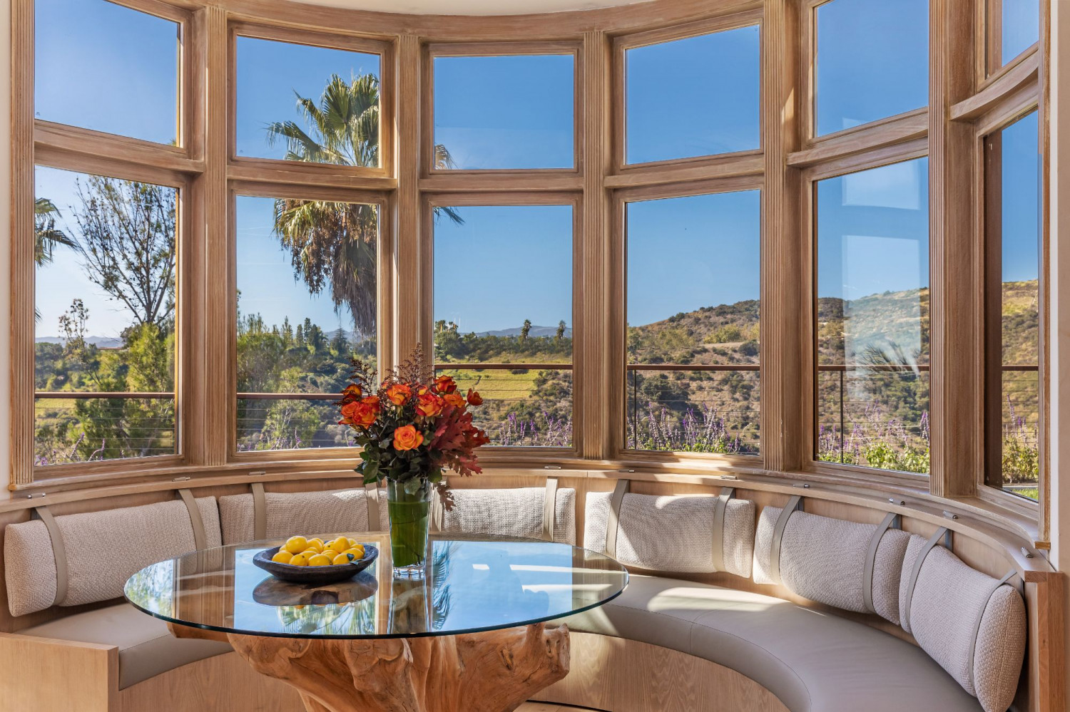 Custom breakfast nook with floor-to-ceiling windows and sweeping canyon views inside a luxury Beverly Hills estate.