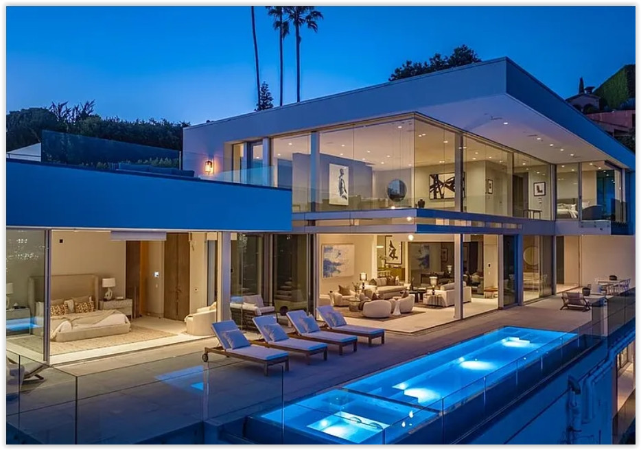 Modern Los Angeles estate with illuminated infinity pool, glass architecture and panoramic city views at dusk