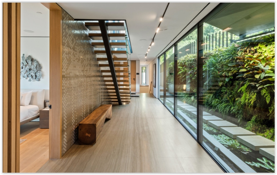 Modern Beverly Hills estate interior with floating staircase, glass walls and living wall