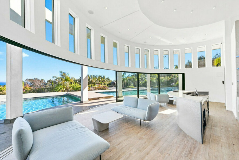 Circular pool pavilion with floor-to-ceiling glass overlooking the resort-style pool at a luxury Malibu ocean view estate.